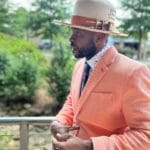 Honed Intention hat by Thrich Brims — lifestyle side-profile shot of a man in a peach blazer wearing the hat outdoors, cream felt with a cognac leather band